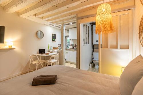 a bedroom with a bed and a dining room at Blois hypercentre, calme, charme avec terrasse in Blois