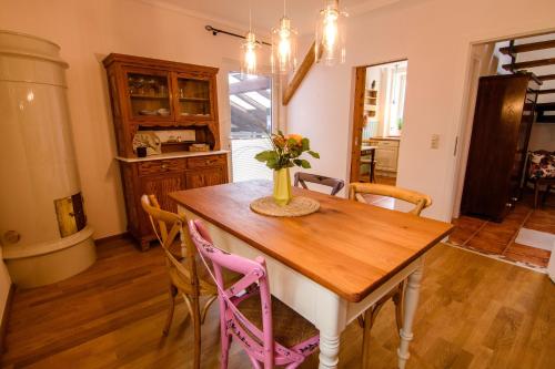 ein Esszimmer mit einem Holztisch und Stühlen in der Unterkunft Gemütliche Wohnung in Bracht mit Terrasse und Garten in Rauschenberg