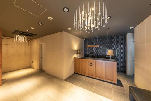 a lobby with a reception desk and a chandelier at Bureau Sitennoji hotel in Osaka