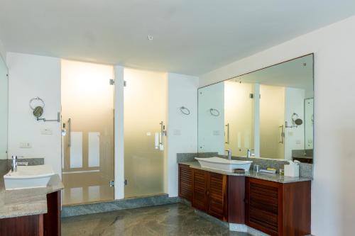 a bathroom with two sinks and two mirrors at By The Bay Kovalam in Trivandrum