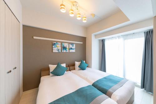 a bedroom with a large bed with blue pillows at Bureau Sitennoji hotel in Osaka