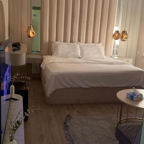 Un dormitorio con una cama grande con un cabecero grande. en Afandina Hotel, en Kuwait