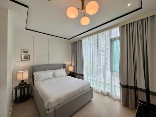 a bedroom with a bed and a large window at Rongratana Executive Residence Bangkok in Bangkok