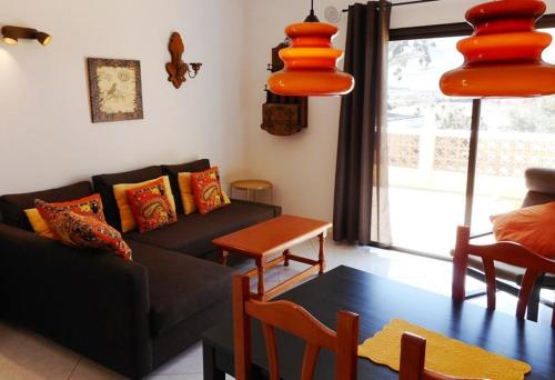 a living room with a couch and a table at Liebevoll Eingerichtetes Apartment Calima Amarilo in La Pared