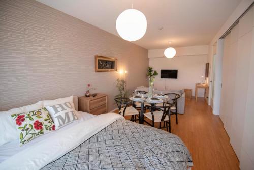 a bedroom with a bed and a dining room at kotinoma kuu in Hakozaki