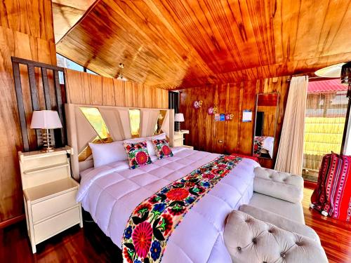 a bedroom with a large bed in a room at Uros Qhantany Lodge in Puno