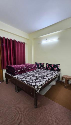 a bed sitting in a room with purple curtains at Shivpuri House Kedarnath in Kedārnāth