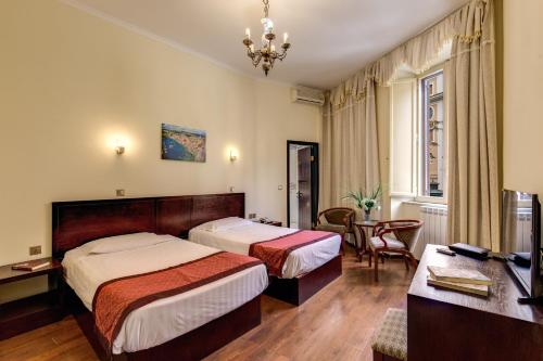 a hotel room with two beds and a desk at New albatros in Rome