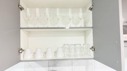 a cupboard filled with glasses on a shelf at Zillion’s Bliss - Basement Suite in Calgary