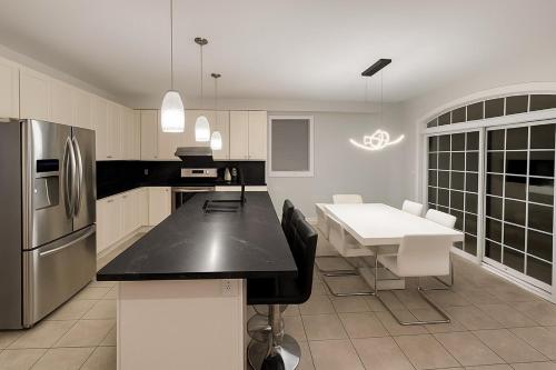 a kitchen with a table and a stainless steel refrigerator at Spacious Brampton 4BR Upper Home in Brampton