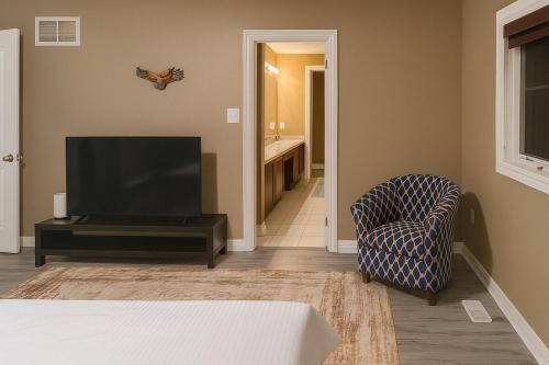 a living room with a tv and a chair at Spacious Brampton 4BR Upper Home in Brampton