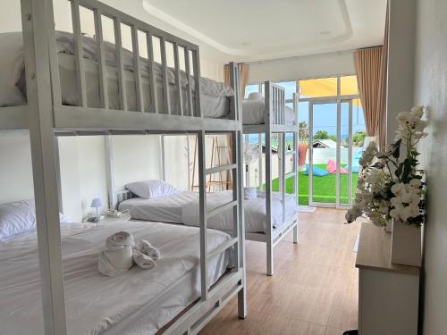 two bunk beds in a room with a balcony at Heaven Thon Pool Villa in Narathiwat