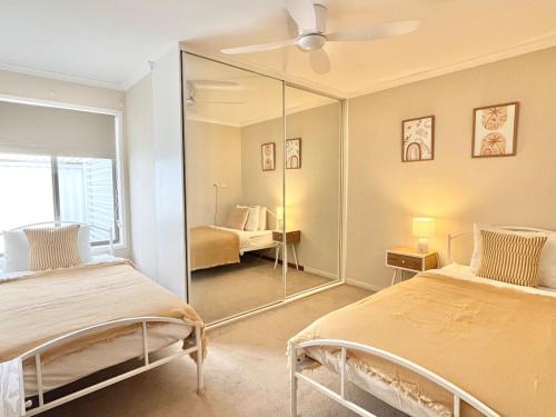 a bedroom with two beds and a mirror at Casa Al Mare- family and pet friendly, close to everything in Gold Coast
