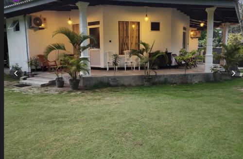 a house with a porch with plants in the yard at Secret Hill Haven in Unawatuna