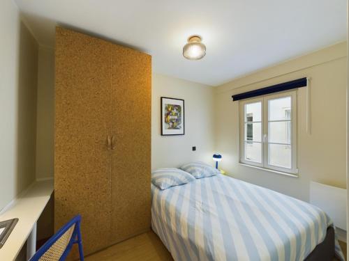 ein Schlafzimmer mit einem Bett und einem Fenster in der Unterkunft Charmant 2 pièces très calme aux pieds de la Cathédrale in Straßburg