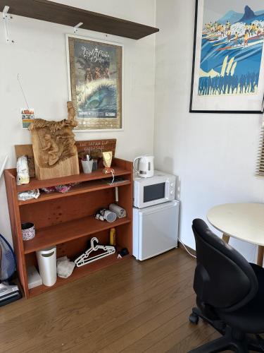 a room with a table and a chair and a microwave at Guest Room Chigasaki in Chigasaki
