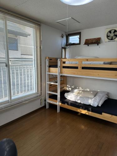 a bedroom with two bunk beds and a window at Guest Room Chigasaki in Chigasaki