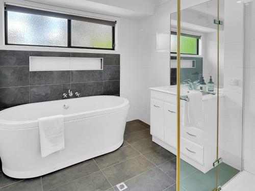 Un baño blanco con bañera y lavabo. en Eildon Views, en Bonnie Doon