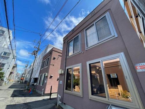 a purple building with windows on a city street at (A5)NEW OPEN☆中心エリアへ好アクセス　格安＆美室で快適空間　サービスアパ―トメントSAPPORO南8条A5 in Sapporo