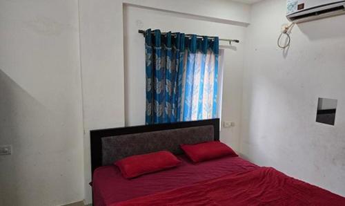 a bedroom with a red bed with two red pillows at FabHotel RK Grand in Hyderabad