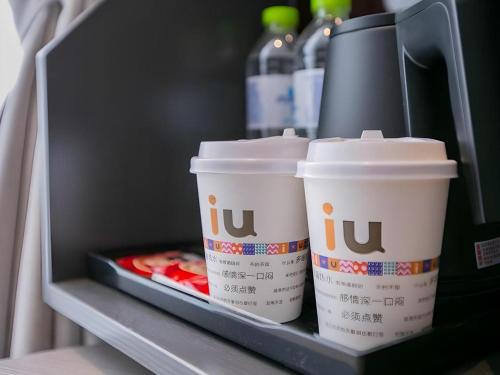 two cups of coffee sitting on a shelf in a refrigerator at IU Hotel Suizhou Shunjing Avenue Passenger Transportation Center in Suizhou
