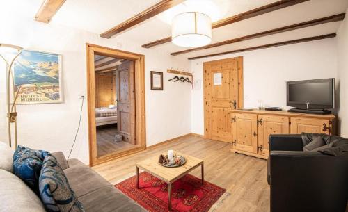 Una sala de estar con un sofá y un televisor en Chesa Treig, en Samedan