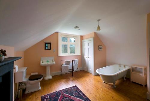 a bathroom with a tub and a toilet and a sink at Ballealy Cottage in Randalstown