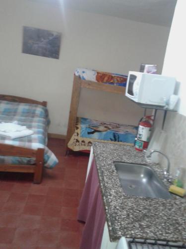 una cucina con lavandino e un divano in una camera di Alquimia a Capilla del Monte