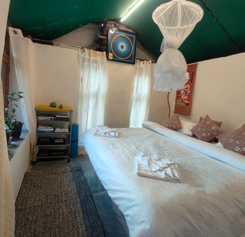 a bedroom with a bed with a green ceiling at Khoj Cottage & Cafe in Dharmsāla