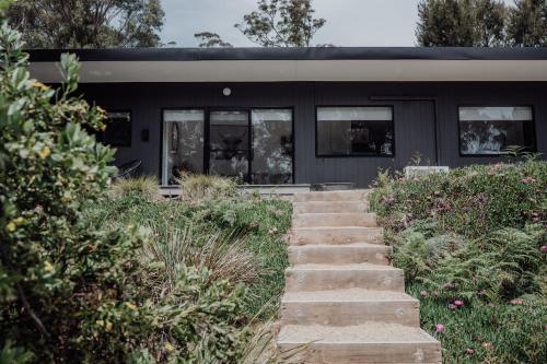 a building with a staircase in front of it at Blyth Retreat, Bruny Island in Simpsons Bay