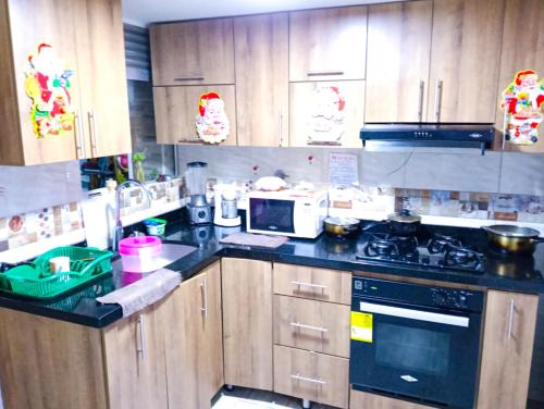 a kitchen with wooden cabinets and a stove top oven at habitacion en casa de familia in Rionegro