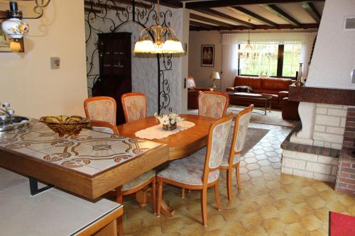 ein Esszimmer mit einem Holztisch und Stühlen in der Unterkunft 4Sterne-Bungalow auf großem Weihergrundstück in Wadern