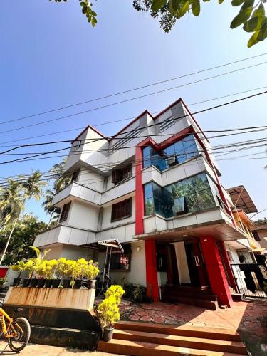 a tall white building with a red trim at devanjana inn in Jāmb