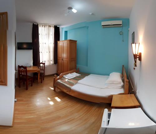 a bedroom with a bed and a blue wall at Pensiunea Muresul in Târgu-Mureş