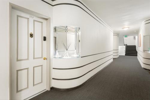 een gang met een wit-zwart gestreepte muur bij Beverly Grove Hotel in Los Angeles