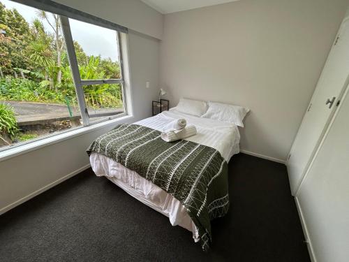 a bedroom with a bed and a window at Northcote holiday home- Next stop CBD in Auckland