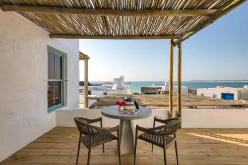 une table et des chaises sur une terrasse avec vue sur l'océan dans l'établissement La Baleine, à Paternoster