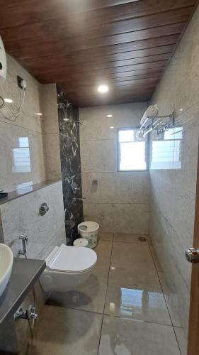 a bathroom with a toilet and a sink at Sai Inn in Satara