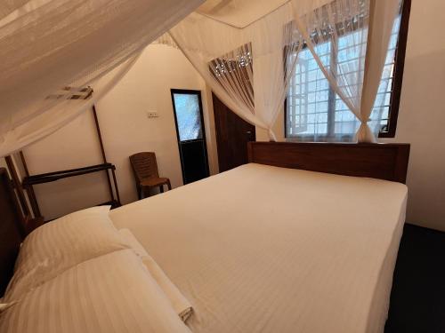 米瑞莎Five Mirissa Homestay的一间卧室，有一张白色的床和一扇窗户