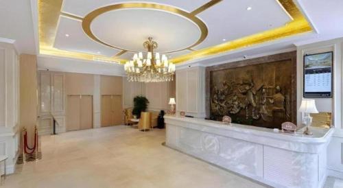 a large lobby with a chandelier and a painting on the wall at Vienna Hotel Jiangxi Shangrao High-Speed Railway Station in Shangrao