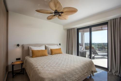 Un dormitorio con una cama con ventilador de techo. en Rodos Nest with terrace and seaview, en Asgourou