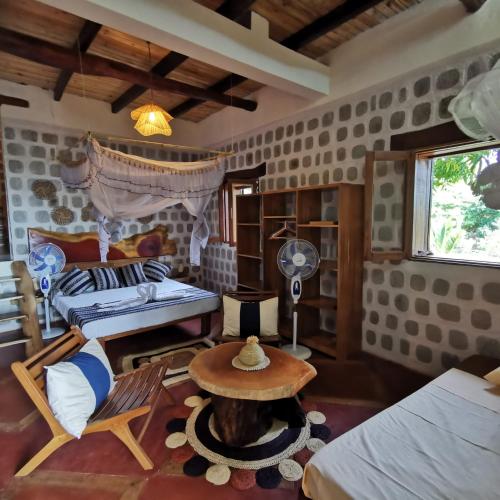 une pièce avec un lit et une table dedans dans l'établissement G&J House - Bulle tropicale, à Andilana