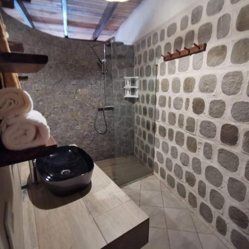 La salle de bains est pourvue d'une douche et de toilettes noires. dans l'établissement G&J House - Bulle tropicale, à Andilana