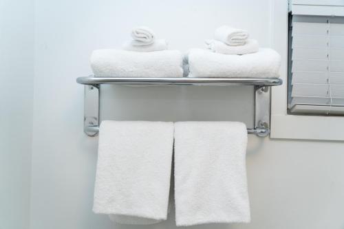 une pile de serviettes sur un porte-serviettes dans une salle de bain dans l'établissement Mountain View Hope Motel, à Hope