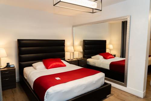 Un dormitorio con dos camas y un gran espejo. en Mountain View Hope Motel, en Hope