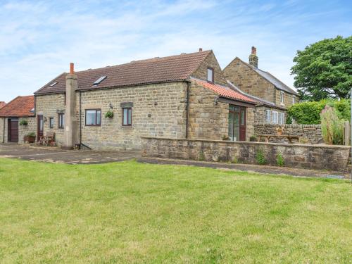 an old stone house with a fence and a yard at Beacon - Uk44719 in Ravenscar