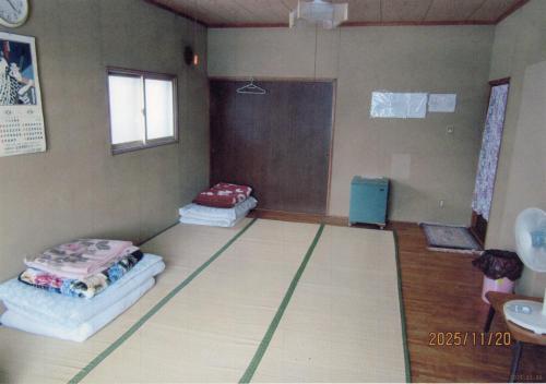 a room with two mattresses on the floor of a room at Minshuku Mutsukari in Furano