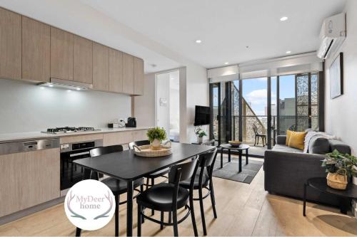 a kitchen and living room with a table and a couch at Heart of Adelaide Luxuy Apt Rundle Mall in Adelaide