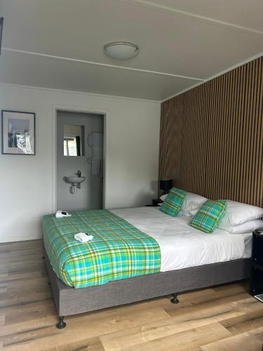a bedroom with a large bed with green pillows at The Prospector Lawrence in Lawrence