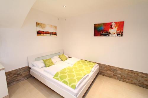 a bed in a room with two pictures on the wall at Apartment Barichgasse in Vienna